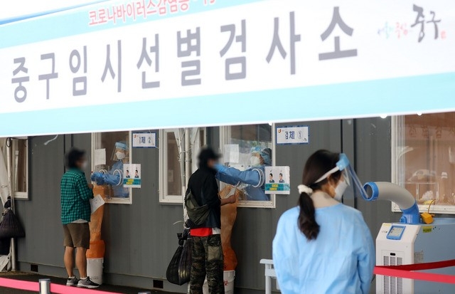 코로나19 신규 확진자가 666명으로 집계된 22일 오전 서울 중구 서울역광장에 마련된 코로나19 중구임시선별검사소에서 의료진이 검체 채취를 하고 있다.