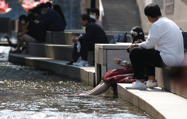 지난 13일 오후 서울 중구 청계천에서 한 시민이 물에 발을 담그고 있다.