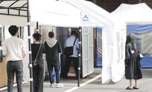 코로나19 신규 환진자가 538명 발생한 24일 서울 중구 국립중앙의료원 선별진료소에서 사람들이 코로나19 검사를 위해 줄지어 대기하고 있다.