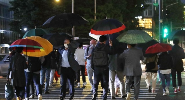 지난 20일 오후 서울 종로구 광화문사거리에서 시민들이 우산을 쓴 채 퇴근길 발걸음을 재촉하고 있다.