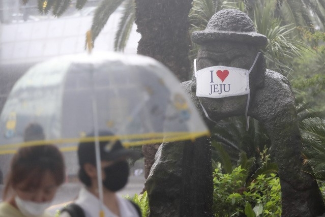 제주국제공항에서 관광객들이 비를 피해 렌터카 보관소로 이동하고 있다.