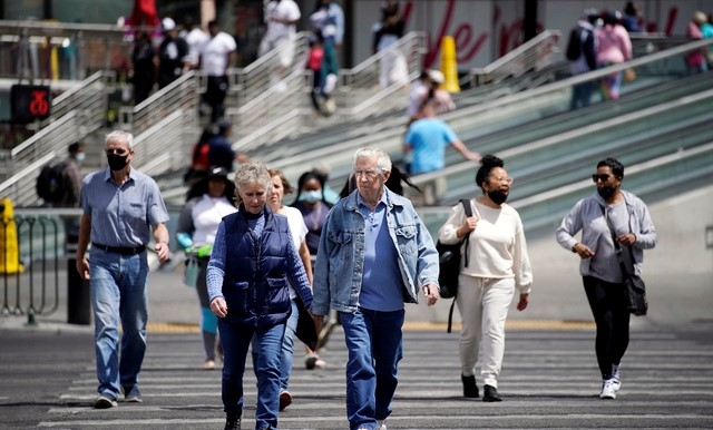 27일(현지시간) 미 네바다주 라스베이거스에서 마스크를 쓰거나 쓰지 않은 보행자들이 거리를 걷고 있다. 미국 질병통제예방센터(CDC)는 코로나19 백신 접종을 완료한 경우 야외에서 마스크를 쓰지 않아도 된다고 발표하며 야외 마스크 착용에 대한 지침을 완화했다.