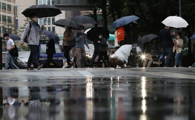 전국에 많은 비가 내린 지난 28일 서울시청 인근 도로에서 우산을 쓴 직장인들이 출근하고 있다.