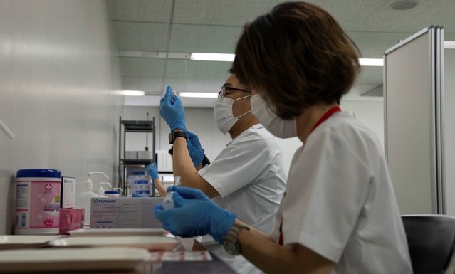 지난 5월 24일 일본 도쿄에 새로 개소한 코로나19 대량접종센터에서 한 노인이 모더나 백신을 접종하고 있다. 일본은 하루 최대 1만5000명의 노인을 대상으로 도쿄와 오사카 두 곳에 대량접종 센터를 개설했다.