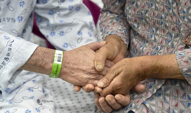 요양병원·시설 입소자나 면회객 중 어느 한쪽이라도 코로나19 예방접종 완료자(2차 접종 후 2주 경과)인 경우 대면 면회가 가능해진 지난 1일 오전 경기도 안산시 단원구 경희재활요양병원에서 아내 이 모씨와 입소자인 남편 김 모씨가 대면 면회에서 두 손을 맞잡고 있다.