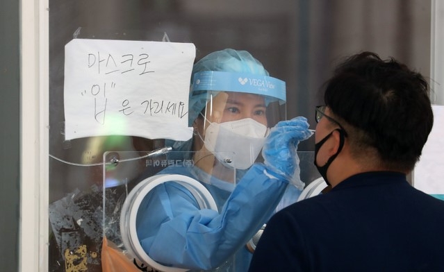 코로나19 신규 확진자수가 10일만에 처음으로 700명대로 집계, 725명을 기록한 5일 서울역 임시선별검사소에서 의료진이 검사 업무를 하고 있다.