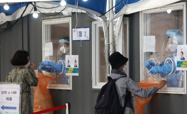 코로나19 신규 확진자수가 주말 검사량 감소 등으로 6일 만에 400명대로 집계된 7일 서울 중구 서울역에 설치된 임시선별검사소를 찾은 시민들이 코로나19 검사를 받고 있다.