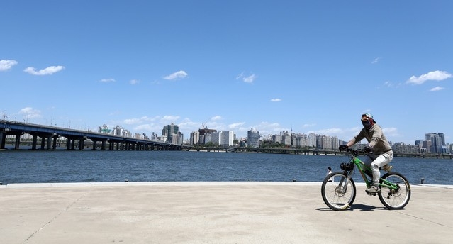 황사가 물러난 9일 오후 서울 영등포구 여의도 한강공원에서 시민이 자전거를 타고 있다.