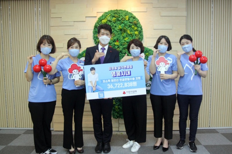 가수 임영웅 공식팬클럽 영웅시대 회원들과 서울 사랑의열매 김진곤 사무처장이 기부금 전달판을 들고 기념촬영을 하고 있다.