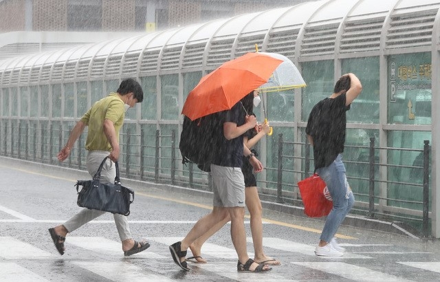 제주국제공항에서 관광객들이 비를 피해 렌터카 보관소로 이동하고 있다.