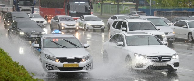 전주시 덕진구 백제대로에서 차량들이 빗물에 잠긴 도로를 달리고 있다.