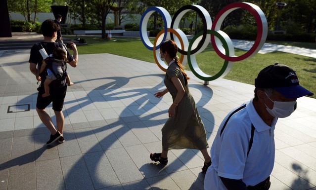 지난 9일 일본 도쿄에 설치된 올림픽 조형물 근처를 시민들이 지나가고 있다.