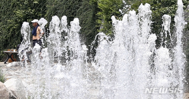 전국 대부분 지역 낮 최고 기온이 30도까지 웃돌며 초여름 날씨를 보인 지난 8일 서울 서대문구 홍제천 인공폭포에서 한 시민이 겉옷을 벗고 더위를 식히고 있다.