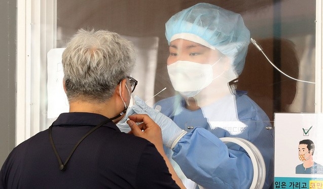 13일 오전 서울 중구 서울역 앞에 마련된 코로나19 선별진료소에서 한 시민이 검체 채취를 받고 있다. 중앙방역대책본부는 13일 0시 기준으로 코로나19 신규 확진자가 전일(565명)보다 113명 줄어든 452명이라고 밝혔다. 추가 사망자는 3명이며 국내 평균 치명률은 1.34%다.