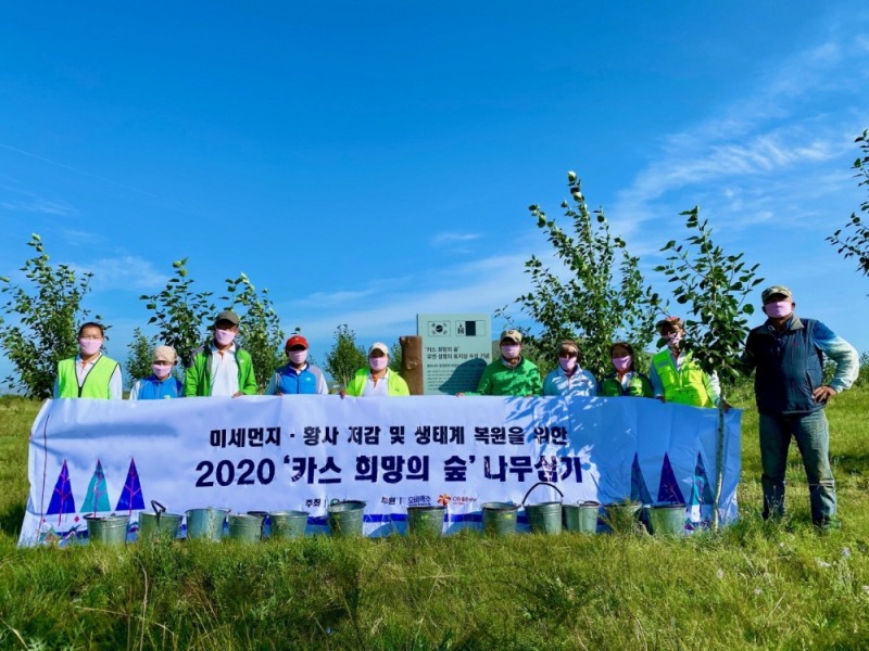 2020년 8월 몽골 에르덴솜 지역에 위치한 '카스 희망의 숲' 일대에서 하늘마을 주민들이 포플러 나무를 식재하고 기념사진을 찍고 있다(사진=오비맥주 제공)