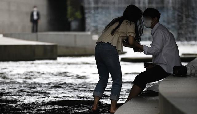 서울 낮 최고기온이 30도까지 오르는 등 더운 날씨가 이어지고 있는 10일 서울 중구 청계천에서 시민들이 물에 발을 담그고 있다.