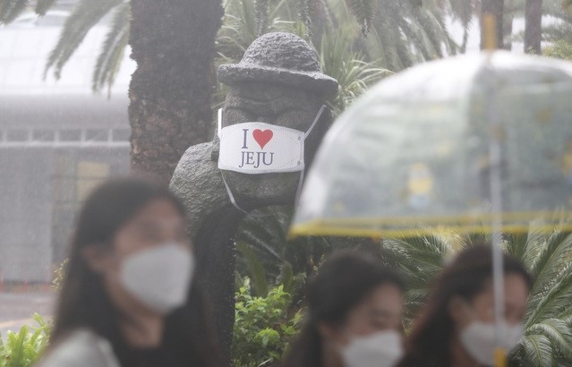제주국제공항에서 관광객들이 비를 피해 렌터카 보관소로 이동하고 있다.