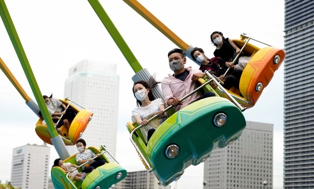 일본 수도권 요코하마에 있는 놀이공원을 20일 찾은 시민들이 코로나19 예방을 위해 마스크를 착용한 채 놀이기구 문어다리를 타고 스릴을 만끽하고 있다. 일본 정부는 내달 도쿄올림픽 개막을 앞두고 21일부로 도쿄도를 비롯한 9개 도도부현에 발령한 긴급사태 선언을 해제한다.