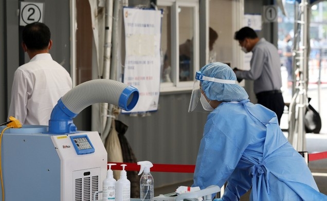 코로나19 신규 확진자가 357명으로 집계된 21일 오전 서울 중구 서울역광장에 마련된 코로나19 중구임시선별검사소에서 의료진이 에어컨 바람을 쐬고 있다.