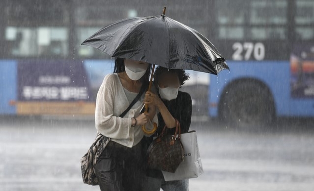 지난 23일 서울 종로구 광화문네거리 인근에서 갑자기 내린 소나기에 시민들이 발걸음을 재촉하고 있다.
