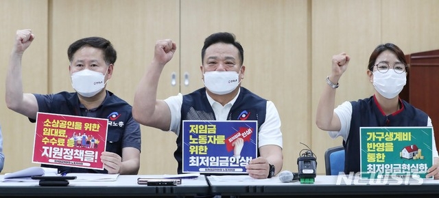 최저임금위원회 근로자위원인 이동호(가운데) 한국노총 사무총장과 박희은(오른쪽) 민주노총 부위원장 등 위원들이 24일 오후 세종시 정부세종청사에서 제5차 전원회의를 앞두고 열린 2022년 적용 최저임금 노동계 최초요구 발표 기자간담회에서 구호를 외치고 있다.