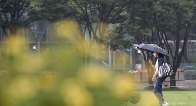 전국에 비가 내린 지난 18일 오전 서울 중구 서울광장에서 한 시민이 우산을 들고 출근길 발걸음을 재촉하고 있다.