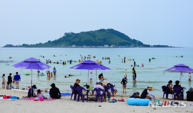 제법 더운 날씨를 보인 25일 오후 제주시 한림읍 협재해수욕장을 찾은 관광객들이 물놀이를 즐기고 있다. 협재·곽지·금릉 등 제주지역 12개 지정 해수욕장은 7월1일부터 8월 말까지 일제히 개장한다.