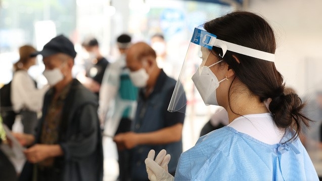 25일 오전 서울 중구 서울역광장에 마련된 임시선별검사소에서 의료진이 검사를 안내하고 있다.