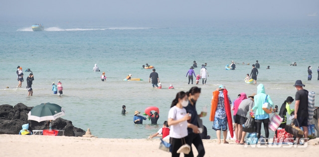절기상 하지인 지난 21일 오후 제주시 조천읍 함덕해수욕장을 찾은 관광객들이 더위를 식히기 위해 물놀이를 하고 있다. 기상청에 따르면 이날 제주 동부 성산읍의 낮기온이 31.0도까지 오르며 제법 더운 날씨를 나타냈다.