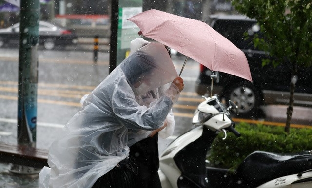 소나기가 내린 지난 23일 오후 서울 종로구 청운효자동주민센터 인근에서 시민들이 우산을 쓰고 걸어가고 있다.