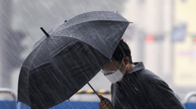 지난 23일 서울 종로구 광화문네거리 인근에서 갑자기 내린 소나기에 시민이 발걸음을 재촉하고 있다.