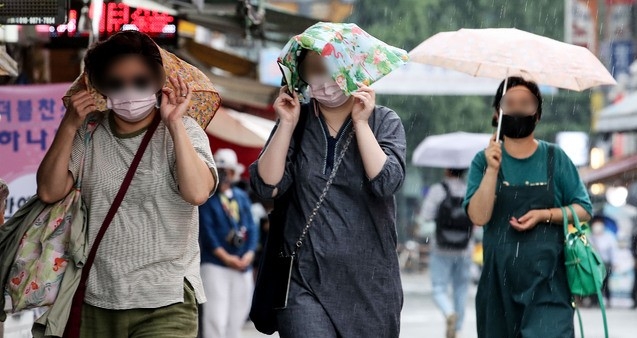 소나기가 내린 23일 오후 서울 중구 남대문시장에서 시민들이 손수건을 이용해 비를 피하고 있다.