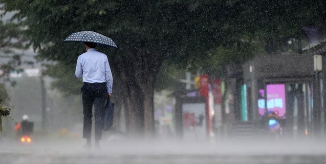 소나기가 내린 22일 오후 서울 강남구 코엑스 인근 도로에서 시민들이 우산을 쓰고 걸어가고 있다.