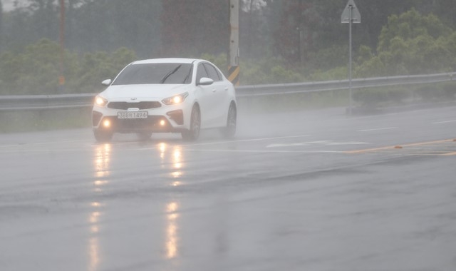비 날씨로 인해 서귀포시 남원읍 인근 도로에 자동차가 대낮에도 전조등 밝히며 달리고 있다.