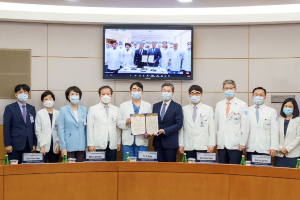 백남종 분당서울대병원장(오른쪽 다섯번째)이 참석자 및 우즈베크 국립암센터 관계자들(화상화면)과 함께 기념 촬영을 하고 있다. 사진=분당서울대병원