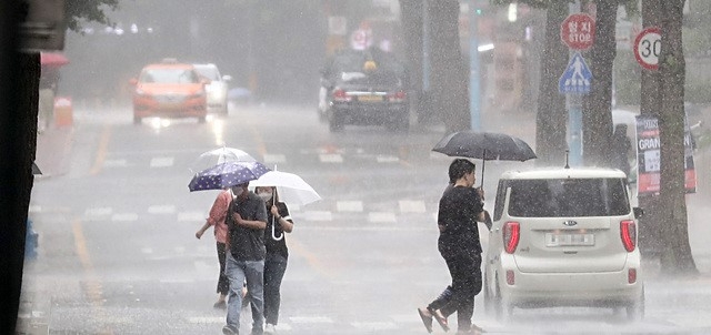 대기불안정에 의해 소나기가 내린 30일 오후 서울 종로구 세종문화회관 일대에서 우산을 쓴 시민들이 발걸음을 옮기고 있다.
