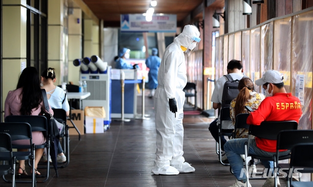 794명의 신규 코로나19 확진자가 발생하고 사회적 거리두기 개편안 시행을 하루 앞둔 30일 오후 서울 송파구보건소에 설치된 코로나19 선별진료소에서 시민들이 검사를 받기 위해 대기하고 있다.