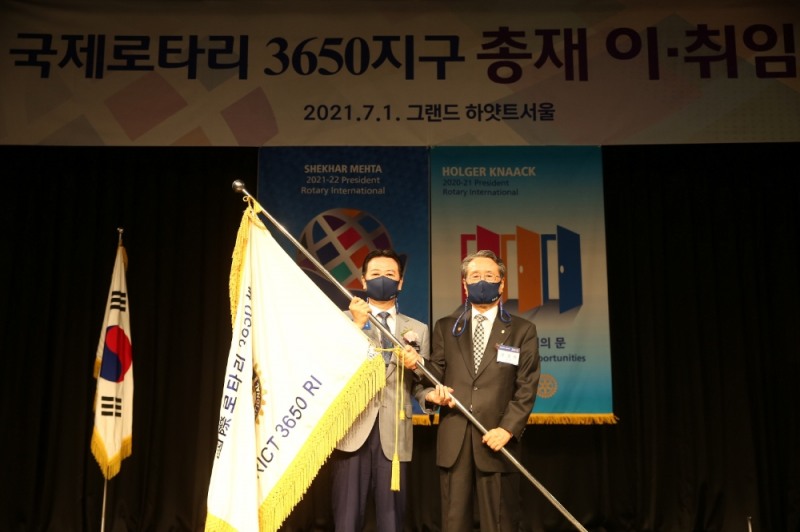 국제로타리 3650지구 총재로 취임한 서창우 한국파파존스 회장이 유장희 전 총재에게서 지구기를 인계받고 있다.(왼쪽부터) 서창우 한국파파존스 회장, 유장희 국제로타리 3650지구 전 총재