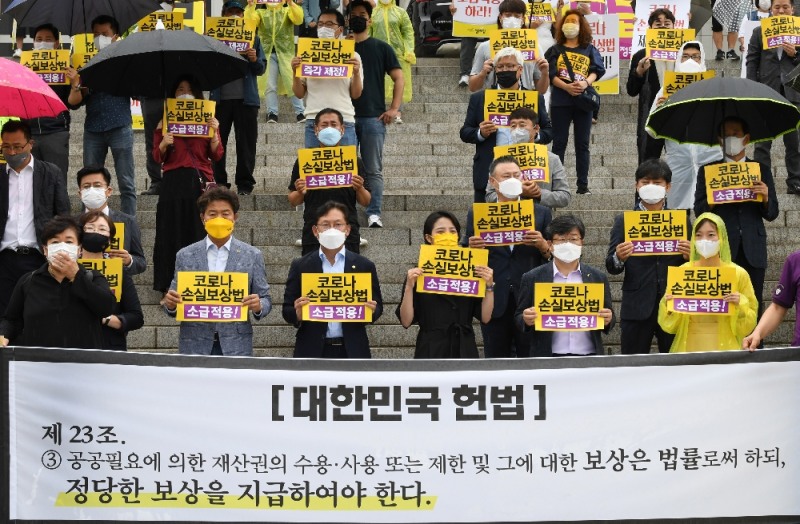 지난달 28일 서울 여의도 국회 본청 앞 계단에서 정의당과 피해상인들이 코로나 손실보상법 소급적용 촉구 결의대회를 하고 있다. (공동취재사진)