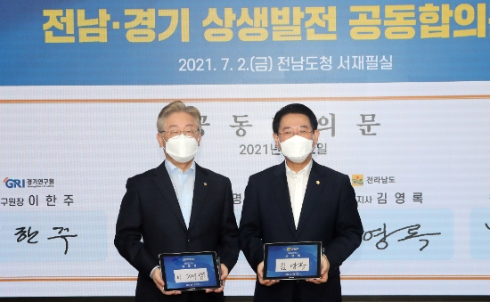 김영록 전라남도지사가 2일 오후 도청 서재필실에서 열린 ‘2021년 전남-경기 상생협력 회의’에서 이재명 경기도지사와 공동합의문에 서명하고 기념촬영을 하고 있다./사진=전라남도