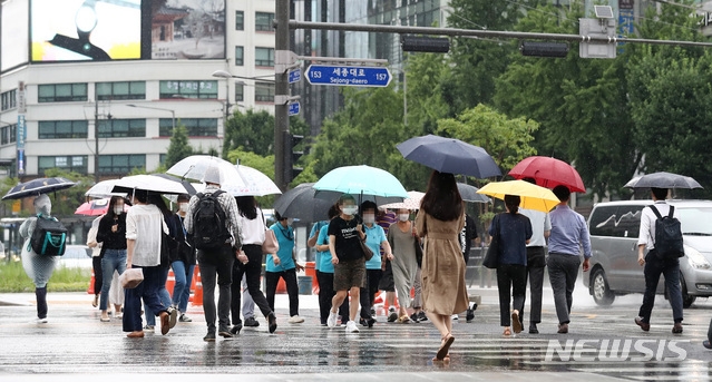 대기불안정에 의해 소나기가 내린 지난 6월 30일 오후 서울 종로구 광화문네거리 일대에서 한 시민이 가방을 머리에 쓰고 비를 피해 발걸음을 옮기고 있다.