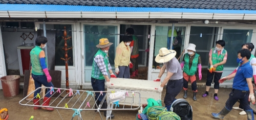 자원봉사자들이 침수피해를 입은 주택에서 피해를 입은 집기류와 물품 등을 옮기고 있다/사진=진도군