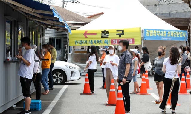 제주보건소 선별진료소에 검체 검사를 기다리는 시민들의 줄이 길게 늘어서 있다.