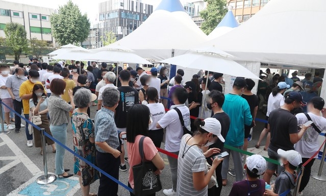 0시 기준 국내 코로나19 신규 확진자가 1615명을 기록하고 있는 지난 14일 서울 강남구보건소 선별진료소를 찾은 시민들이 검사를 기다리고 있다.