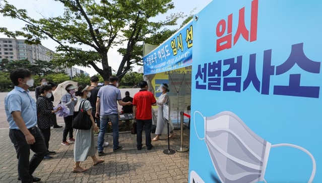 여의도 금융가 전직원들에 대한 코로나19 전수 검사가 진행된 지난 16일 오후 서울 여의도공원에 설치된 임시선별검사소에서 시민들이 검사를 받기 위해 대기하고 있다.