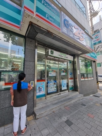 편의점 업계가 사회공헌을 강조하며 상생에 힘쓰고 있다. GS25 편의점 점원이 매장에 설치된 도움벨을 확인하고 있다./ 사진 제공 = GS25