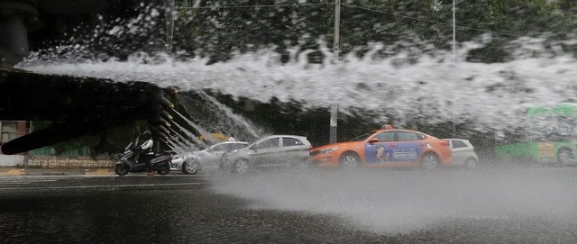 정부가 폭염 위기경보 수준을 '경계' 단계로 격상한 20일 오후 서울 양천구 도심에서 양천구 청소행정과 폭염대응 도로살수차량이 도로 살수작업을 하고 있다.