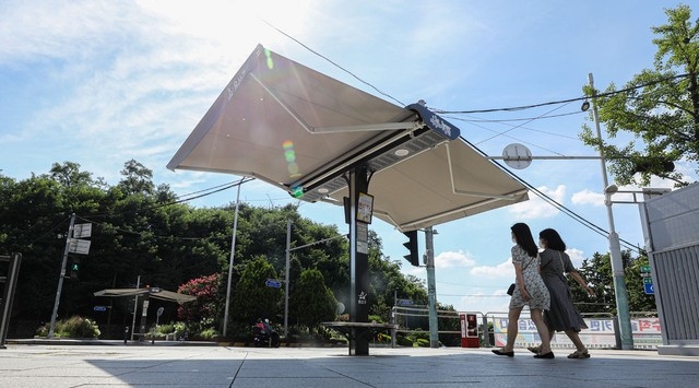 연일 폭염이 이어지고 있는 지난 21일 오후 서울 용산구 녹사평역 인근 교차로에 '스마트 그늘막'이 펼쳐져 있다. '스마트 그늘막'은 온도·바람 등 기상변화에 따라 자동으로 개폐된다.