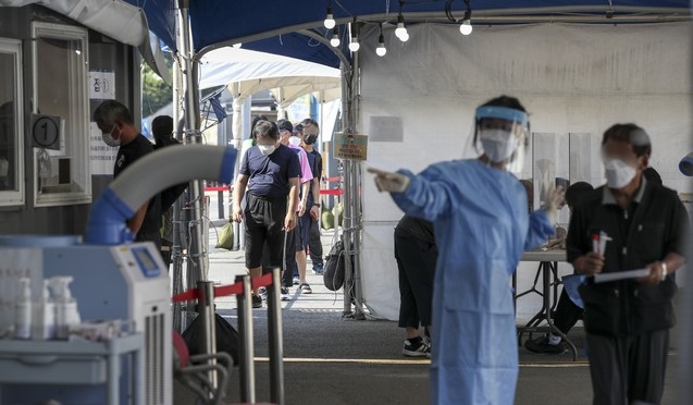 지난 24일 서울역 광장에 설치된 중구 임시선별검사소를 찾은 시민들이 검사를 받기 위해 줄 서 있다.