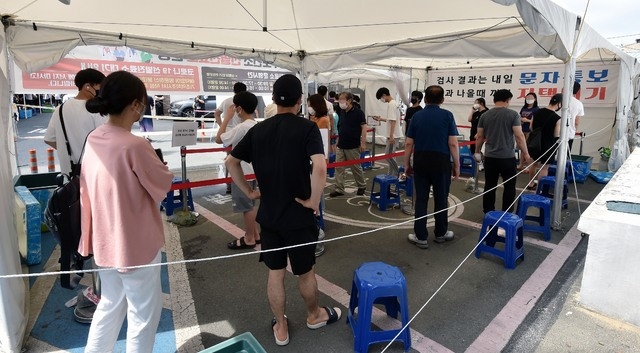 대구지역 코로나19 확진자가 69명으로 집계된 25일 오전 대구 수성구 보건소 코로나19 선별진료소에서 시민들이 검사를 받기 위해 줄 서 기다리고 있다.